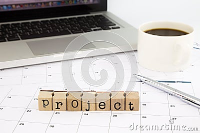 Project wording, calendar and laptop on office table Stock Photo