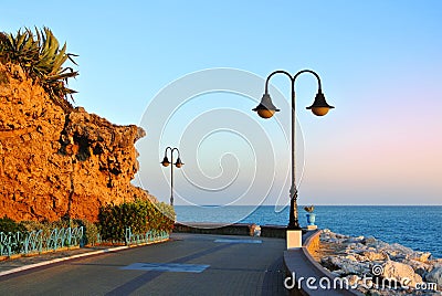 Promenade of Torremolinos, a road, rocks, blooming bushes and Mediterranean sea Stock Photo