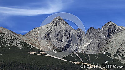 Prominent mountain with observatory on the top and wind blown clouds. Cable car building and ski slopes in the foreground, High Stock Photo