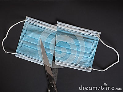 Proper disposal of used medical mask cut to prevent reuse Stock Photo
