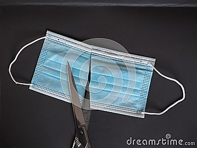 Proper disposal of used medical mask cut to prevent reuse Stock Photo