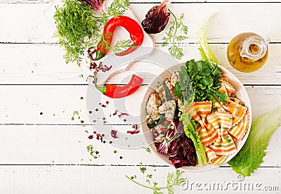 Farfalle pasta durum wheat with baked chicken fillet with eggplant, zucchini and salad in bowl. Stock Photo