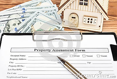 Property assessment form on clipboard over table with model of house and money Stock Photo