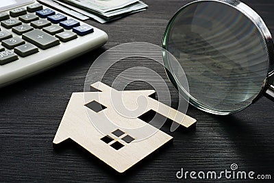 Property assessment. Wooden house with magnifier. Stock Photo