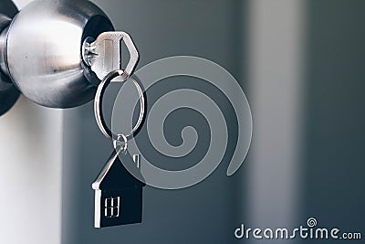 Property Concept, Home key with metal house keychain in keyhole Stock Photo