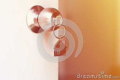 Property Concept, Home key with metal house keychain in keyhole Stock Photo