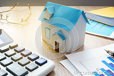 Property invest. Model of house and financial information about real estate market. Stock Photo