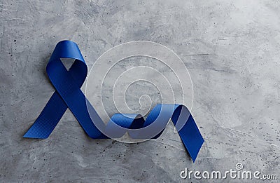 Prostate Cancer Awareness Campaign Concept. Men Healthcare. Close up of a Blue Ribbon Lying on Rough Grey Cement Concrete Stock Photo