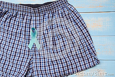 Prostate Cancer Awareness, light Blue Ribbon with male underpants on blue wooden background Stock Photo