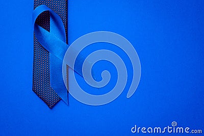 Prostate care. Awareness prostate cancer of men health in November. Blue ribbon, fashion tie isolated on deep blue background. Stock Photo