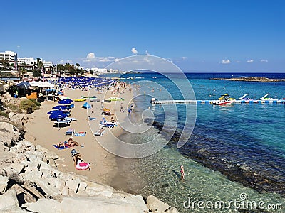 Protaras. Famagusta area. Cyprus. Fig Tree Bay Beach, small island opposite, people sunbathing and swimming on a sunny autumn day Editorial Stock Photo