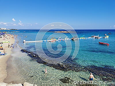 Protaras. Famagusta area. Cyprus. Fig Tree Bay Beach, small island opposite, people sunbathing and swimming on a sunny autumn day Editorial Stock Photo