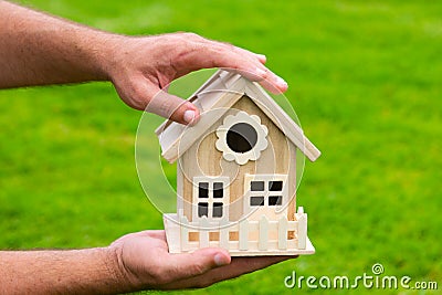 Protect your house concept. House in caring female hands. New home. Stock Photo