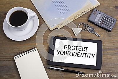 Protect Your Identity. Text on tablet device on a wooden table Stock Photo