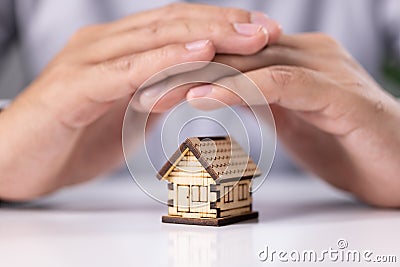 Protecting hands over house, Home security and insurance Stock Photo