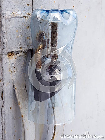 Protecting a padlock against rain with a plastic bottle Stock Photo