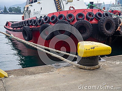 Protection of the sides of the ship in the form of old tires. Scale for submerging a ship in water. Tugboat in the port. The ship Stock Photo