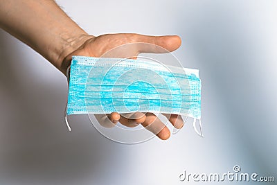 Protective face mask in hand. Surgical mask. Medical mask and corona virus protection. Stock Photo
