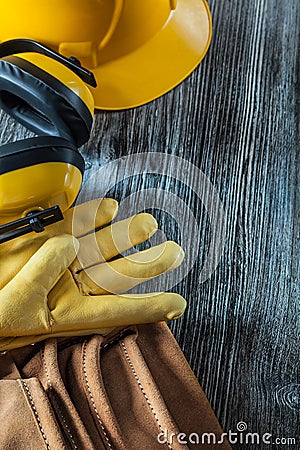 Protective gloves building helmet earmuffs tool belt on wooden b Stock Photo