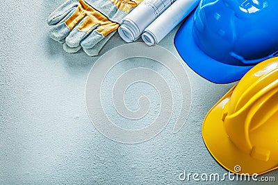 Protective gloves building helmets blueprints on concrete backgr Stock Photo