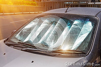 Protective reflective surface under the windshield of the passenger car parked on a hot day, heated by the sun`s rays inside the Stock Photo