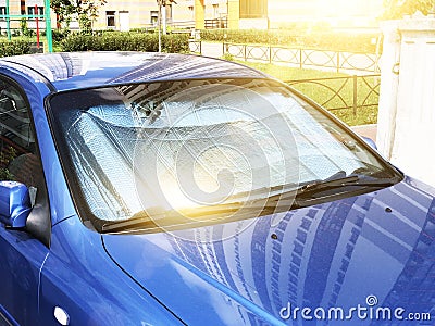 Protective reflective surface under the windshield of the passenger car parked on a hot day, heated by the sun`s rays inside the Stock Photo