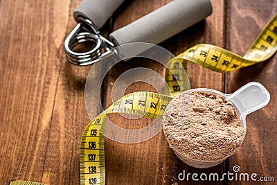 Protein powder for fitness nutrition to start training and measure tape wooden background Stock Photo