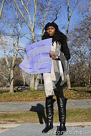 A protester holds a sign during a march against police brutality and grand jury decision on Eric Garner case on Grand Army Plaza Editorial Stock Photo