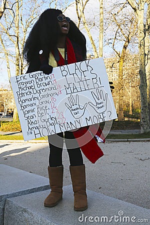 A protester holds a sign during a march against police brutality and grand jury decision on Eric Garner case on Grand Army Plaza Editorial Stock Photo