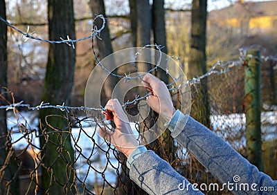 Protesting woman with child and man. overcome the barbed wire, praying and gestures of supplication. indicating that they want fre Stock Photo