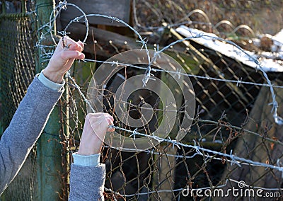 Protesting woman with child and man. overcome the barbed wire, praying and gestures of supplication. indicating that they want fre Stock Photo
