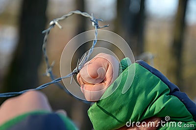 Protesting woman with child and man. overcome the barbed wire, praying and gestures of supplication. indicating that they want fre Stock Photo