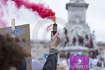 A protestor holds a smoke bomb at a political demonstration Stock Photo