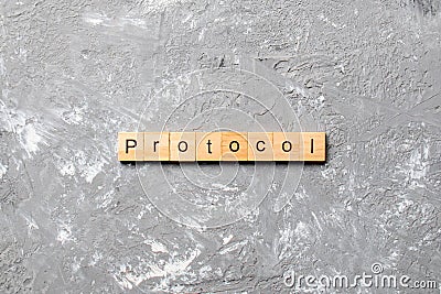 PROTOCOL word written on wood block. PROTOCOL text on cement table for your desing, concept Stock Photo