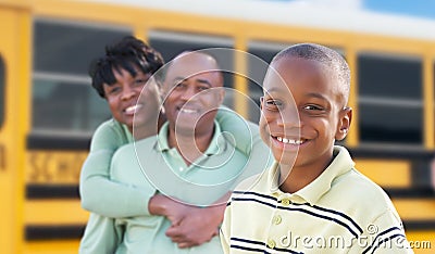 Proud African American Parents and Young Boy Near School Bus Stock Photo