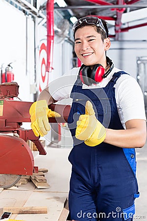 Proud Asian carpenter showing thumbs up Stock Photo