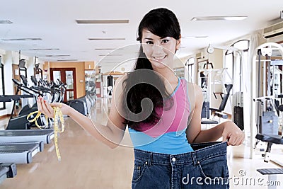 Proud asian woman showing her weight loss Stock Photo