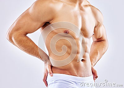 Proud of the body Ive worked hard for. a man posing in his underwear against a white studio background. Stock Photo
