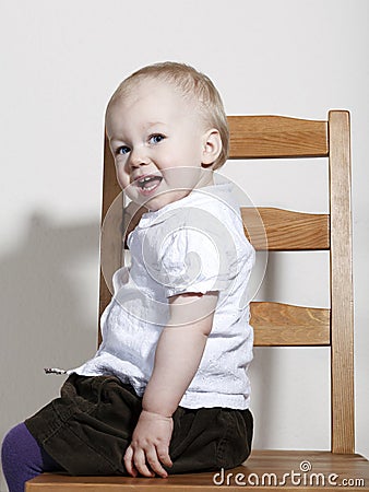 Proud happy baby girl sitting on chair Stock Photo