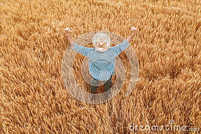 Proud happy victorious barley farmer with hands raised in V Stock Photo