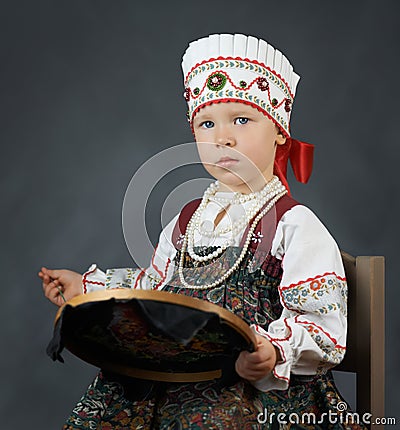 Proud little girl in the traditional russian sarafan during embroidering Stock Photo