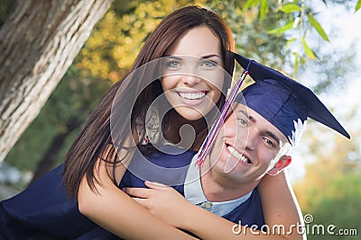 Proud Male Graduate in Cap and Gown and Girl Stock Photo