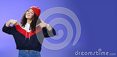 Proud and self-satisfied happy young energized stylish female model in warm beanie brag about own achievements as Stock Photo