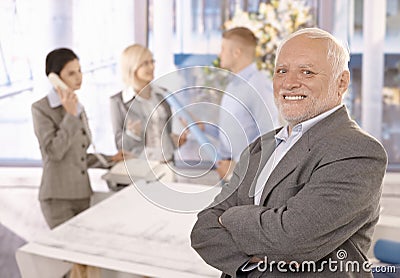 Proud smiling senior businessman with team Stock Photo