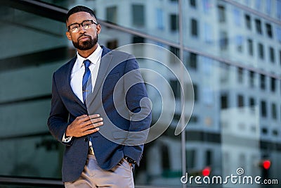 Proud successful businessman executive CEO african american, standing confidently with arms folded in downtown, financial building Stock Photo