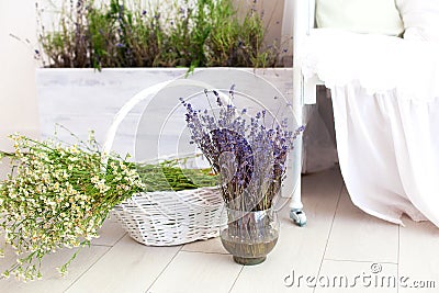 Provence, rustic style, Lavender! A large basket with field daisies and a vase of lavender are on the floor in the bedroom. Aromat Stock Photo