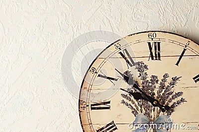 A Provence style decoupage clock hangs on the wall. Roman numerals Stock Photo