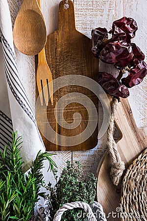 Provence style rustic kitchen interior, wood cutting boards, hanging linen towel, string with dry peppers Stock Photo