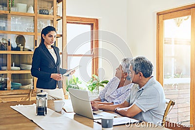 She provides the most helpful advice. a mature couple getting advice from their financial consultant at home. Stock Photo