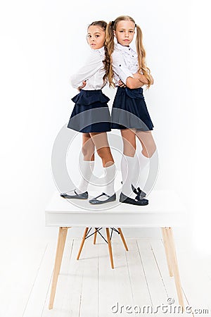 Providing children with education. Small children standing on table in classroom. Little children enjoying school break Stock Photo